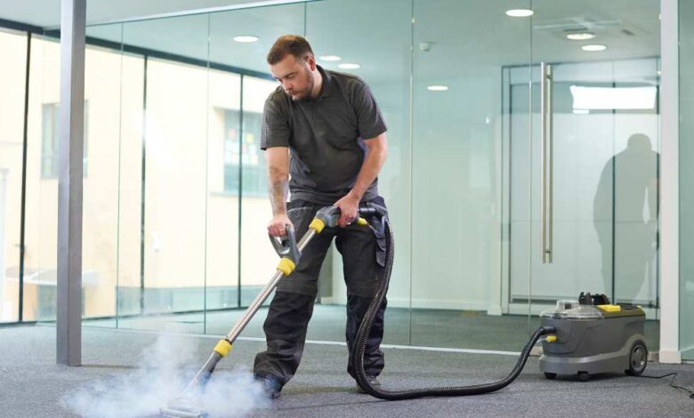 a man in black t-shirt and black pant using steam cleaner on the floor | best floor steam cleaners