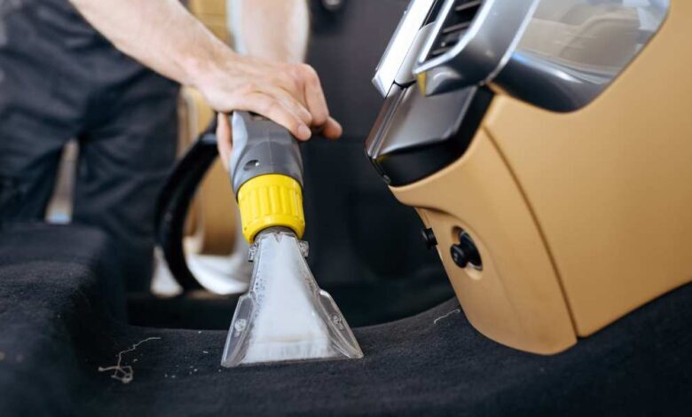 a person washing car with the help of vacuum cleaners