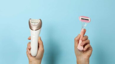 A person holding razor in his left hand and hair clipper in his right hand