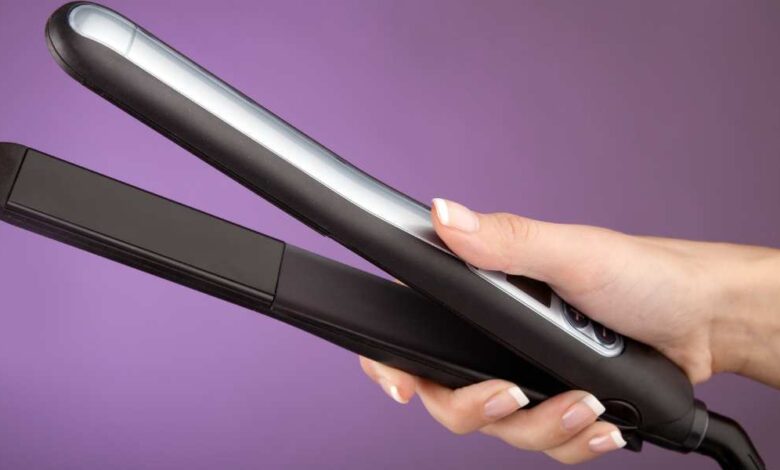 a person holding a black Corioliss Straightener