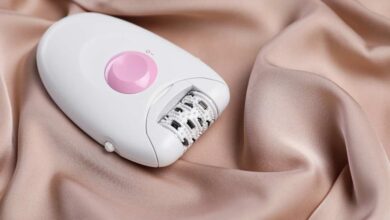 An electri epilator lying on skin colored bedsheet
