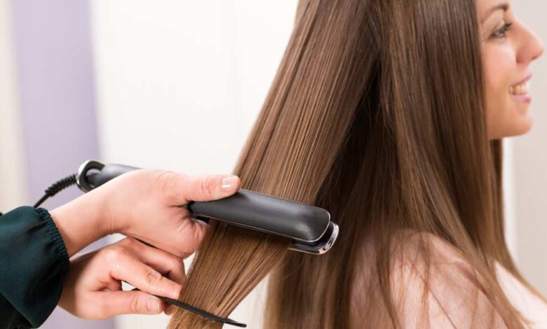 a person straightening gir hair with ghd original styler straightener