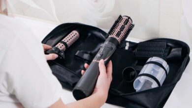 A girl in white t-shirt holding black color dyson airwrap | dyson airwrap review