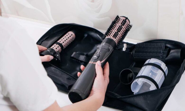 A girl in white t-shirt holding black color dyson airwrap | dyson airwrap review
