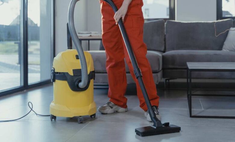 a person in orange pant using yellow color hot ash vacuum cleaner
