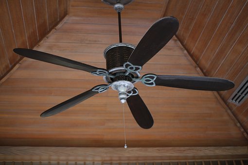 a black colored ceiling fan hanging on the upper ceiling of the bedroom